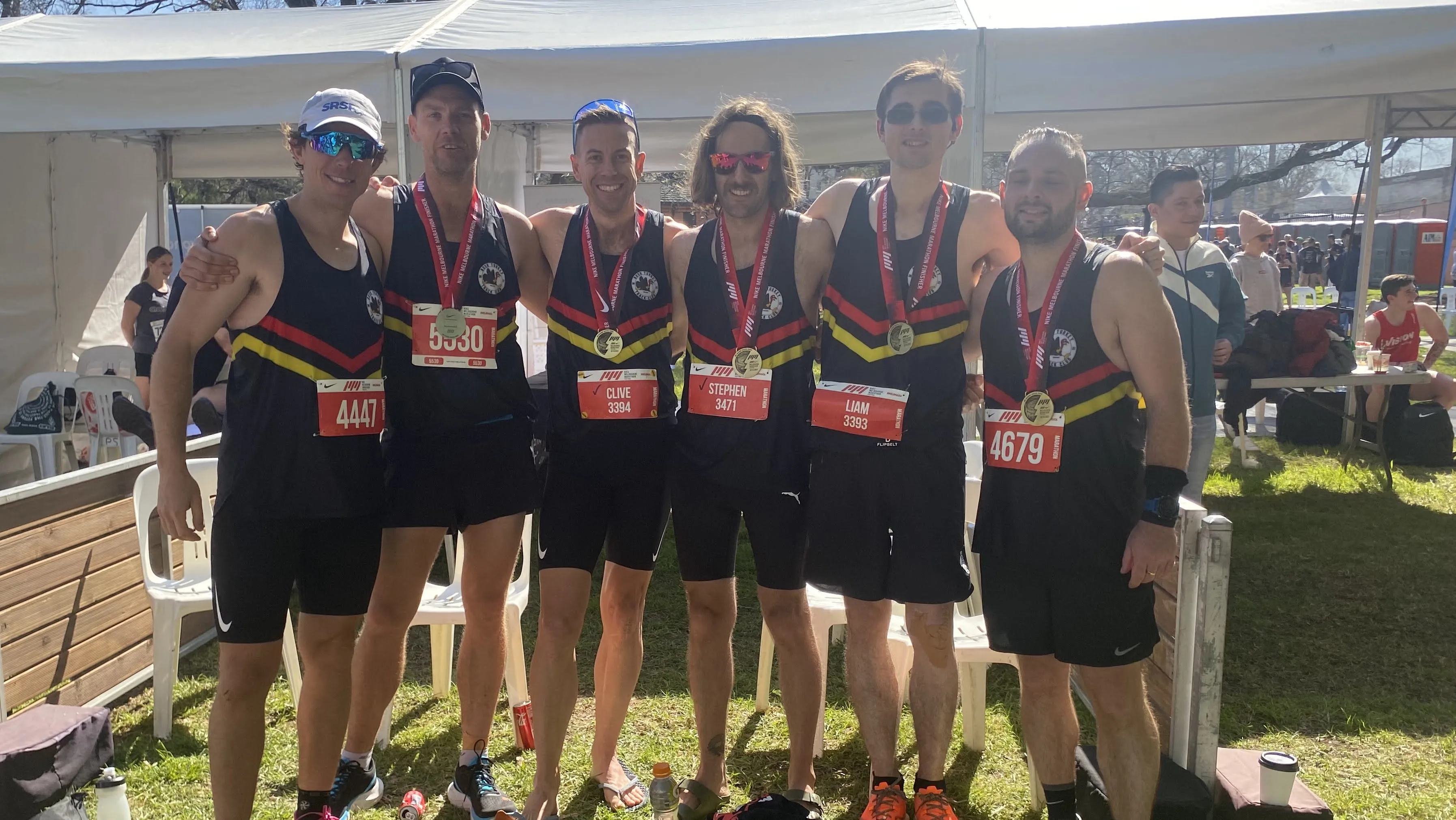 Six club members with their finisher medals after the Melbourne Marathon